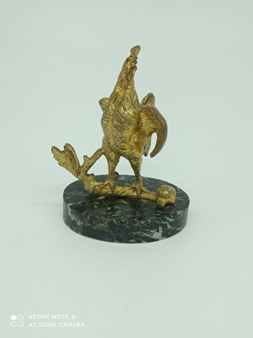 Triumphant rooster on gold metal
