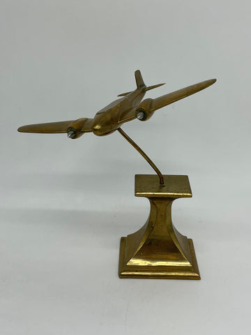 Sleek brass airplane model, on base