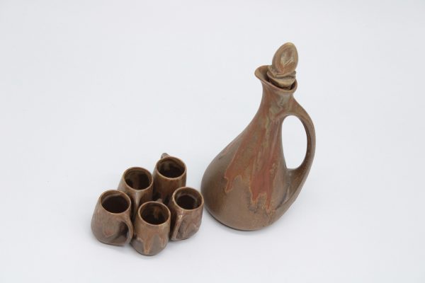 Unique Brown stoneware liqueur set with drip decor, comprising of a carafe and five glasses with handles on a circular tray.DENBAC