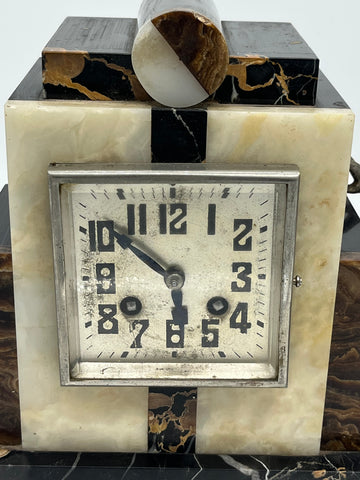 a marble clock with statue