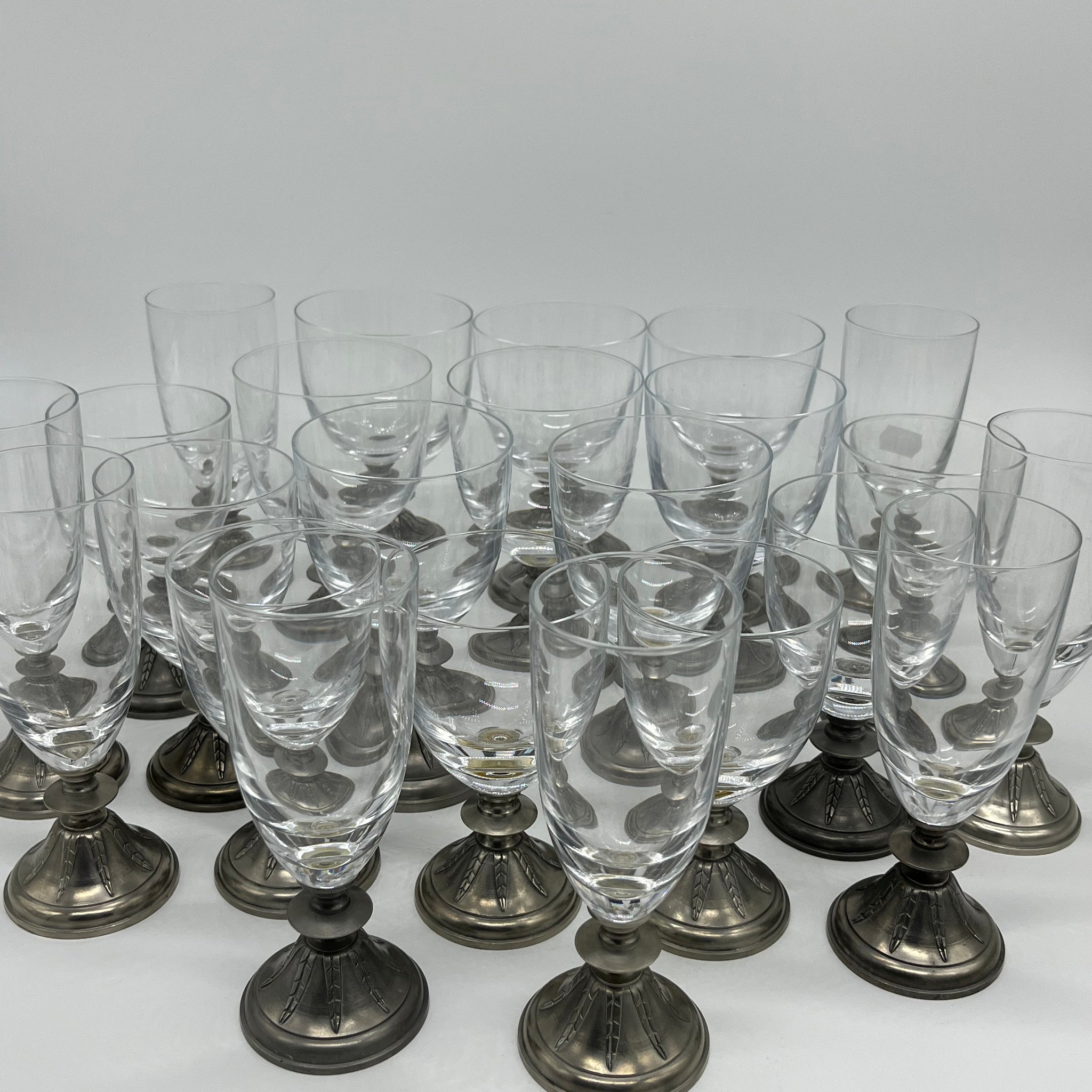 A service of glasses, pewter base, eight champagne glasses, eight water glasses and seven wine glasses