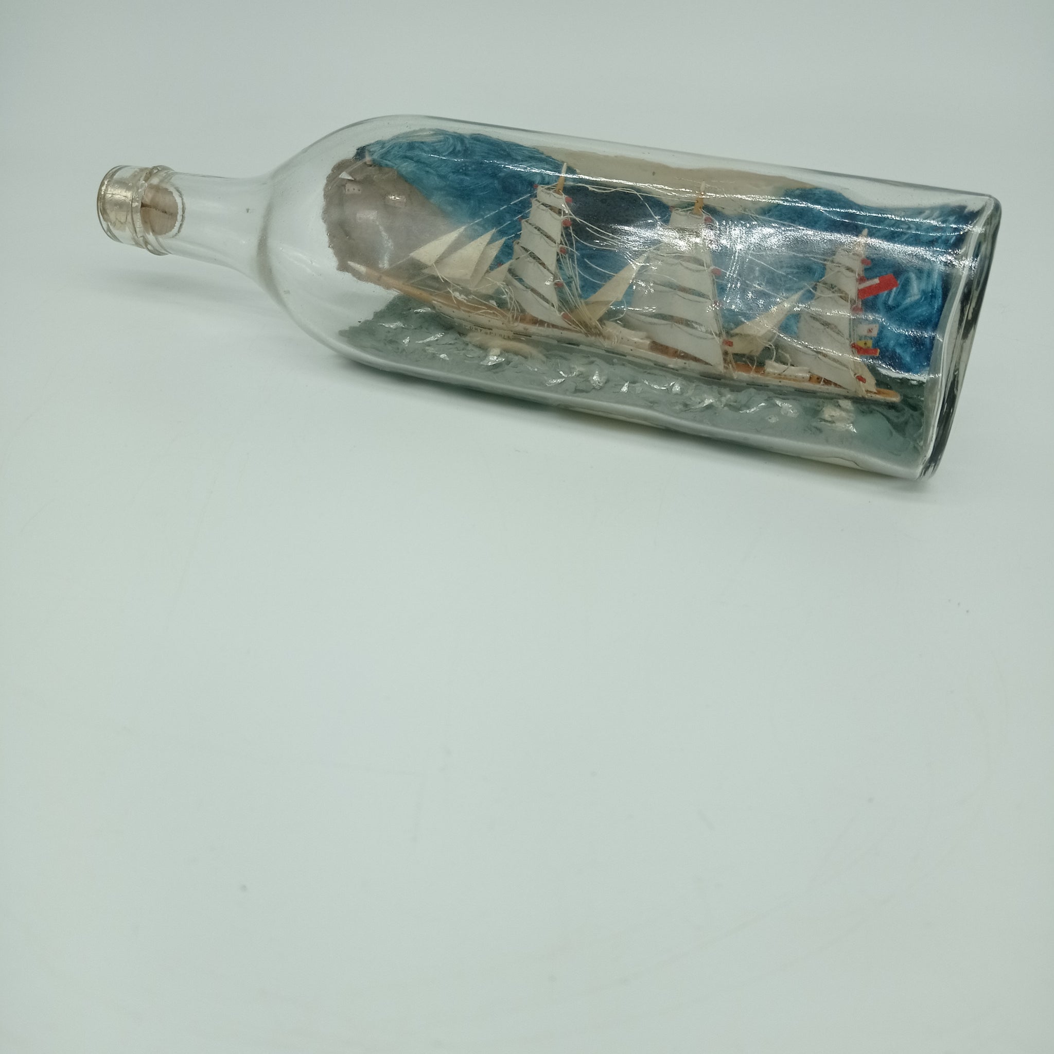 Ship model in bottle with blue background